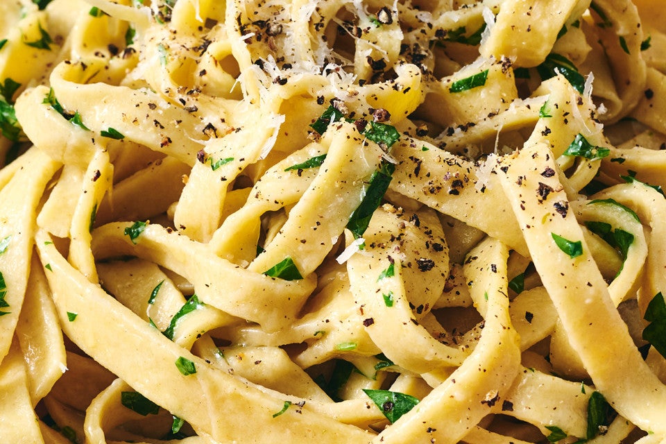 Detailed photograph of gluten free pasta with cracked pepper, parmesan, and herbs.