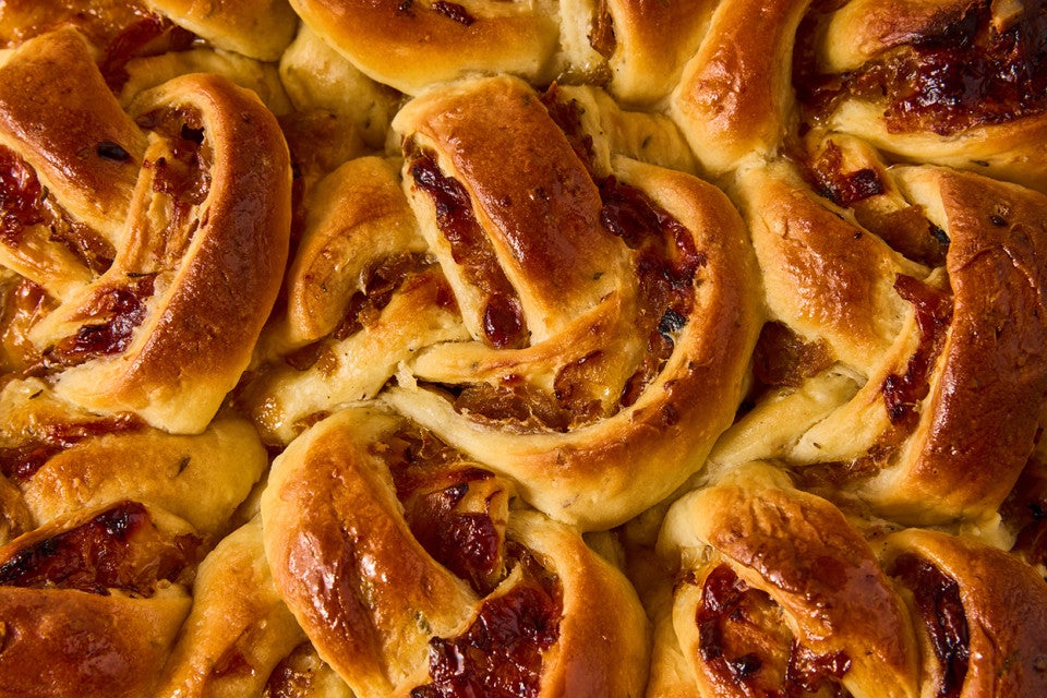 A detail shot of French Onion Rolls showing golden baked roll layers and caramelized onions.