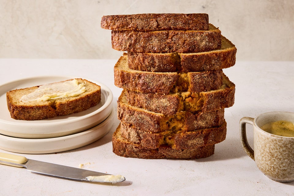 A stack of High-Altitude Banana Bread shown from the side depicting a dark, perfectly baked exterior.