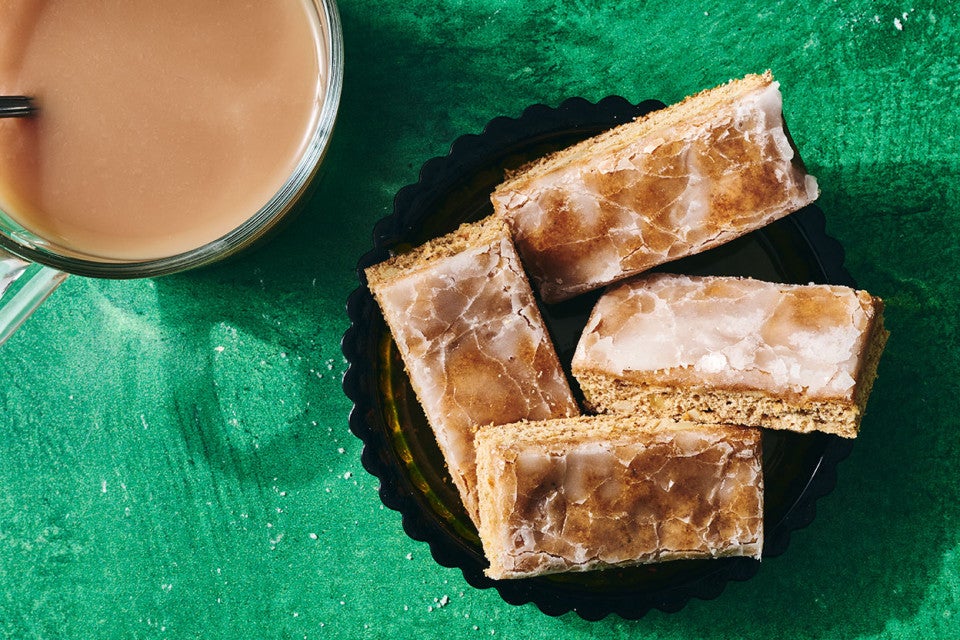 Lebkuchen bars on a plate with a beverage in the corner of the corner of the photo.