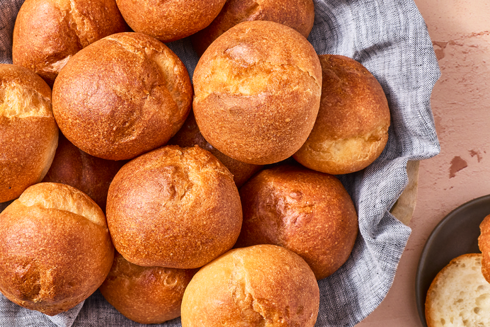 Freshly baked gluten-free rolls in a basket seen from above.