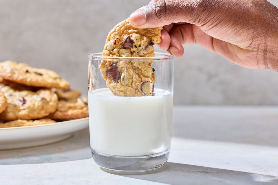 Dipping a Cream Cheese Chocolate Chip Cookie into a glass of milk.