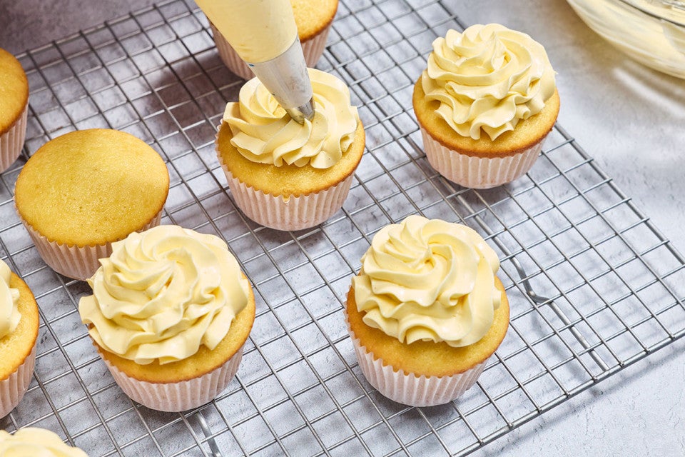 Piping French Buttercream onto cupcakes