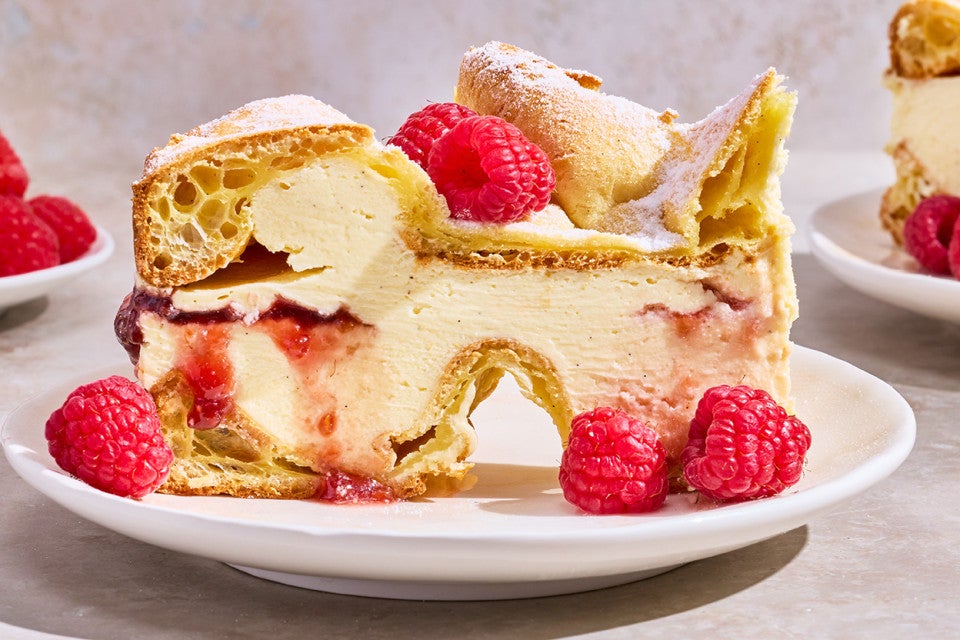 Karpatka Cake on a plate decorated with fresh raspberries.
