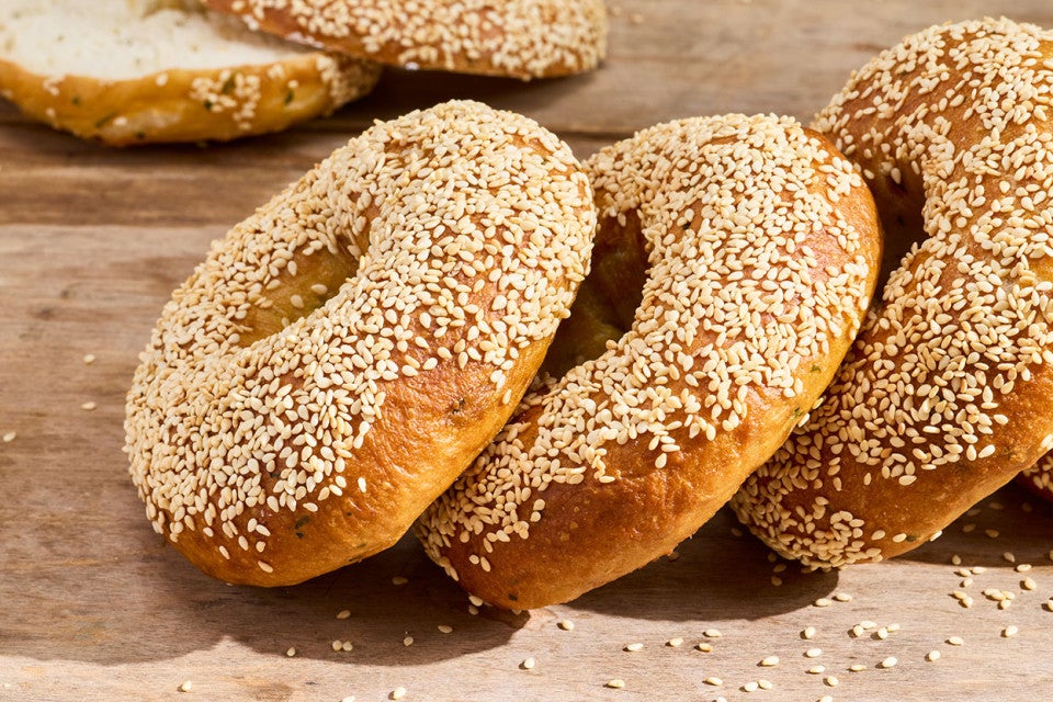 Sesame Sourdough Discard Bagels arranged on a table top.