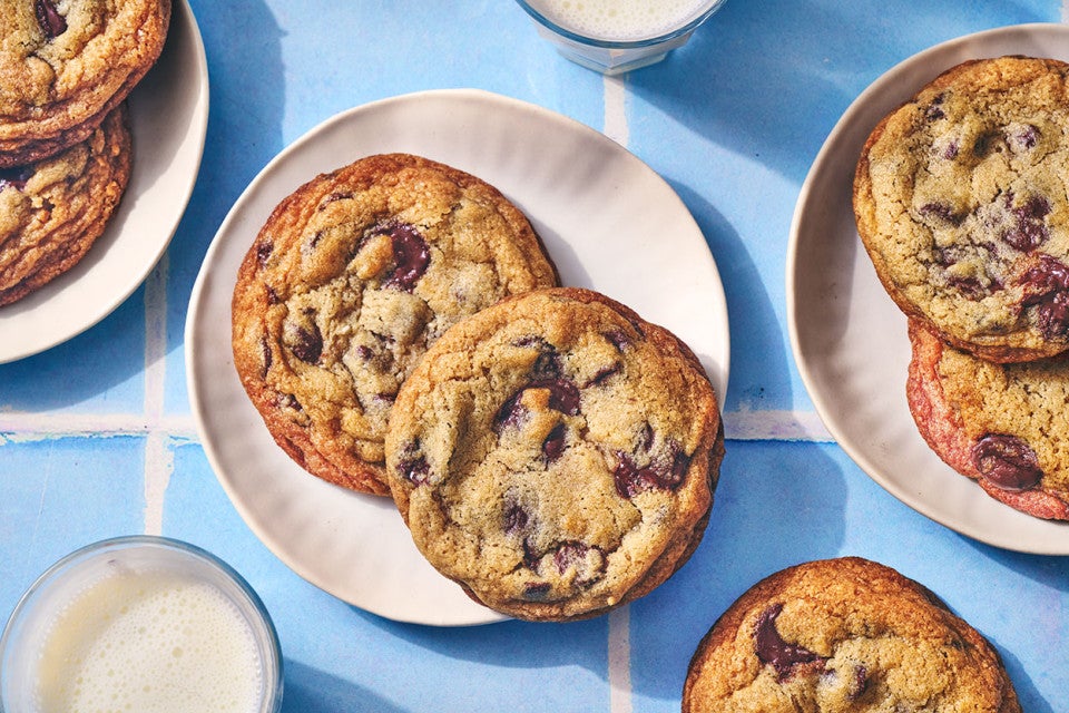 Classic Chocolate Chip Cookies on plates atop a blue counter.