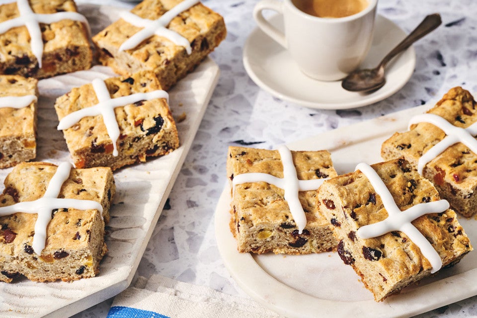 Gluten Free Hot Cross Biscuits on a table with a coffee in the background.