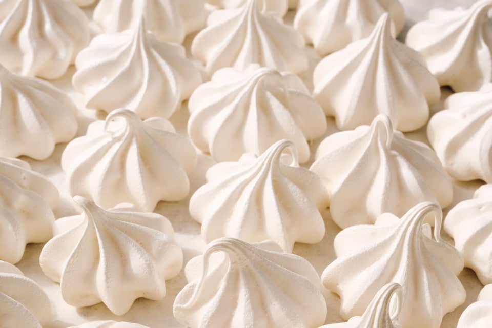 Detailed shot of Meringue Kisses tightly organized on a counter.