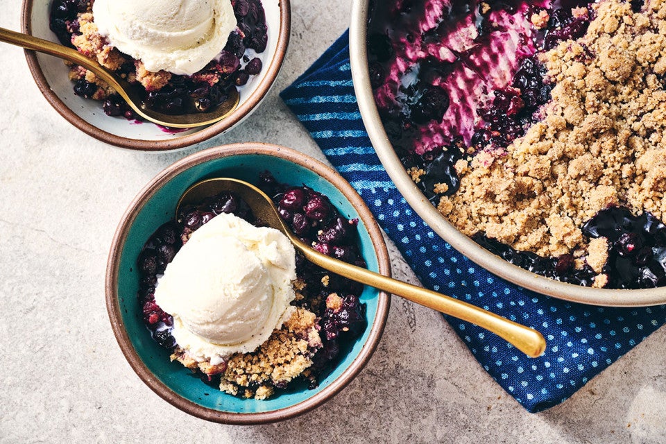 Blueberry Crisp in a round King Arthur Baking pie tin and also in a bowl topped with ice cream