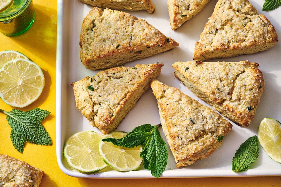 Mojito Scones on a platter with limes and mint leaves decorating the photo.