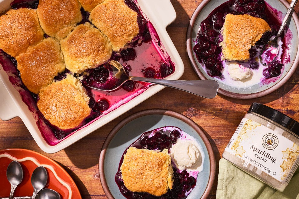 Sourdough Discard Blueberry Cobbler in a pan with slices on plates seen from above