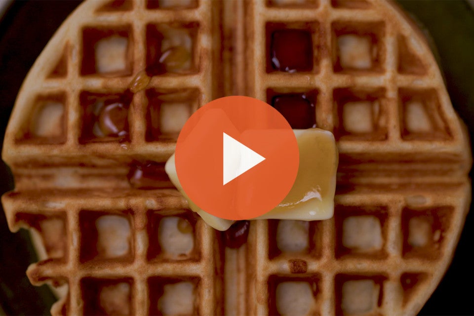 A belgian style yeasted waffle with a play icon over it.