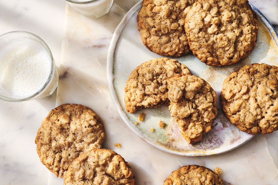 Oatmeal Cookies seen from above on a white plate with a glass of milk in the corner of the image