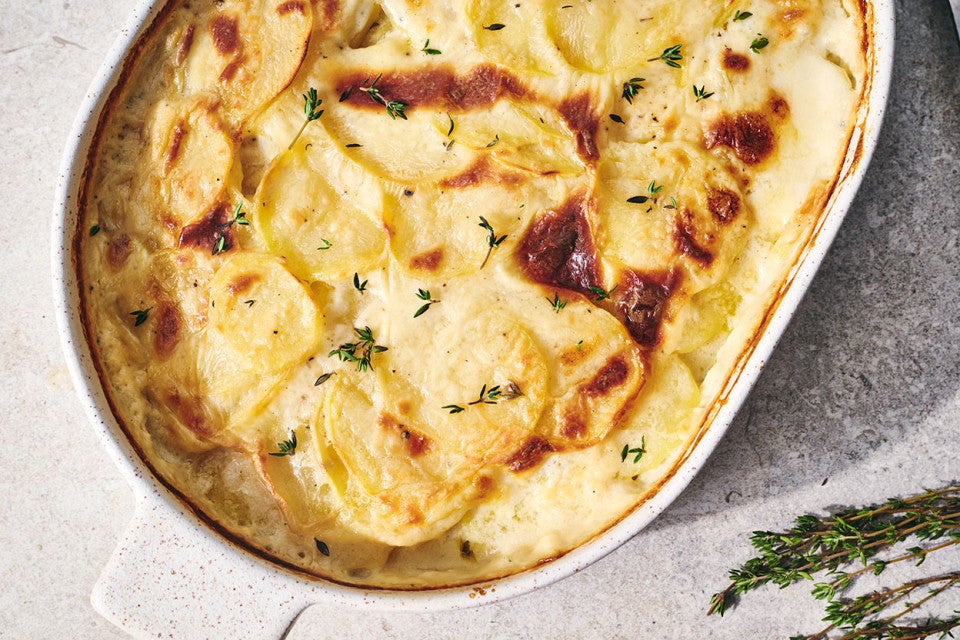 Scalloped Potatoes fresh out of the oven in a stoneware pan seen from above
