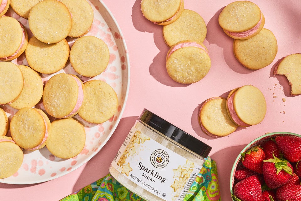 Strawberry Shortcake Cookies seen from above on a pink counter and stacked on a plate