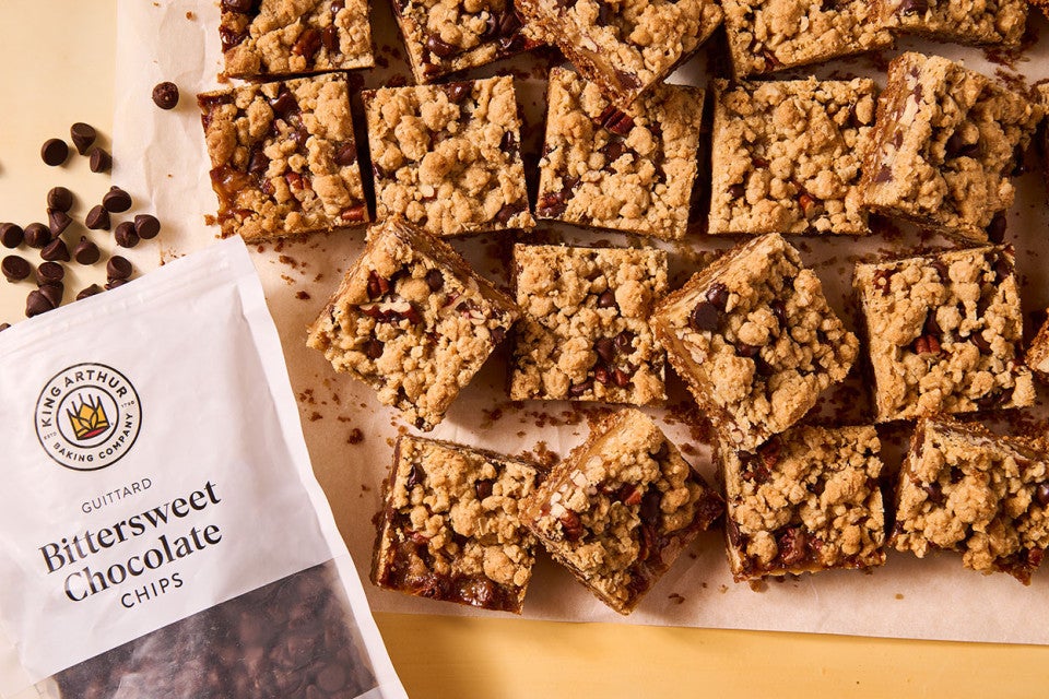 Carmelitas seen from above with a bag of King Arthur Baking's Bittersweet Chocolate chips