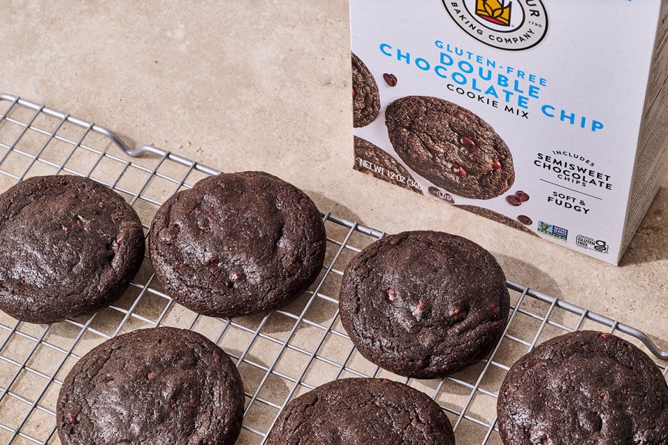 Gluten Free Nutella-Stuffed Cookies on a cooling rack with a box of gluten free double chocolate chip cookie mix in the background
