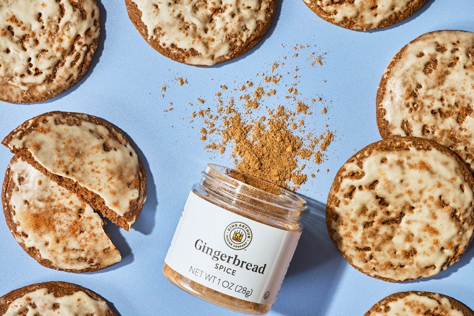 Gingerbread Latte Cookies arranged on a blue backdrop with a jar of King Arthur Baking Gingerbread spice