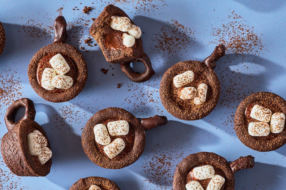 Hot Cocoa Cookie Cups arranged on a blue counter - seen from above.