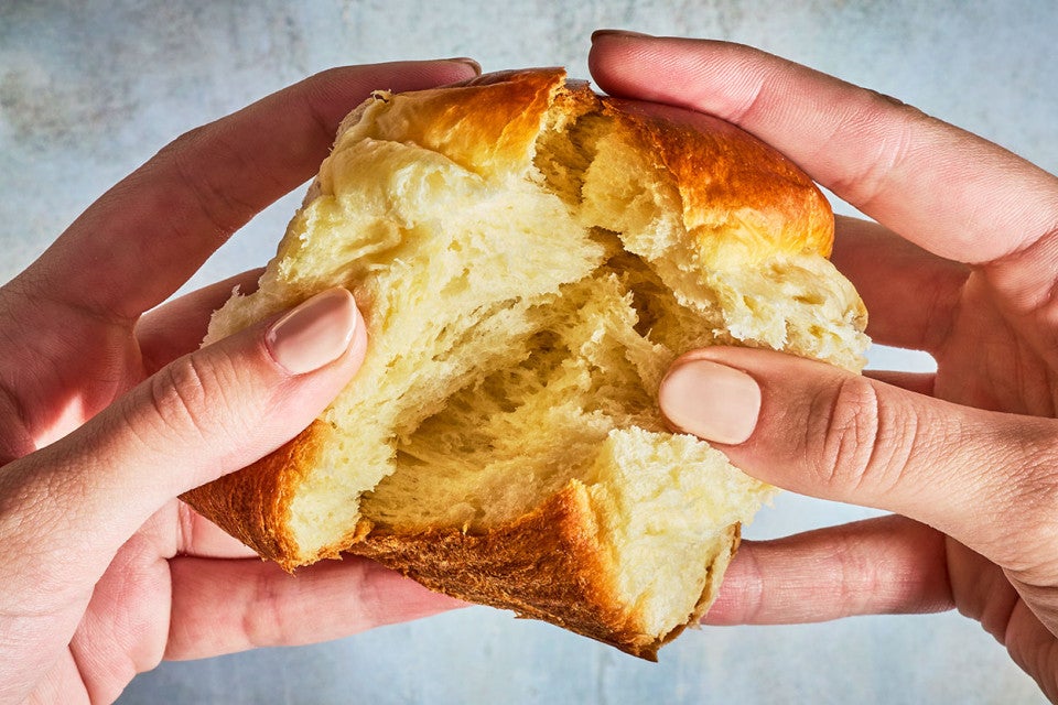 Breaking apart a Japanese Milk Bread Roll to show the pillowy interior.