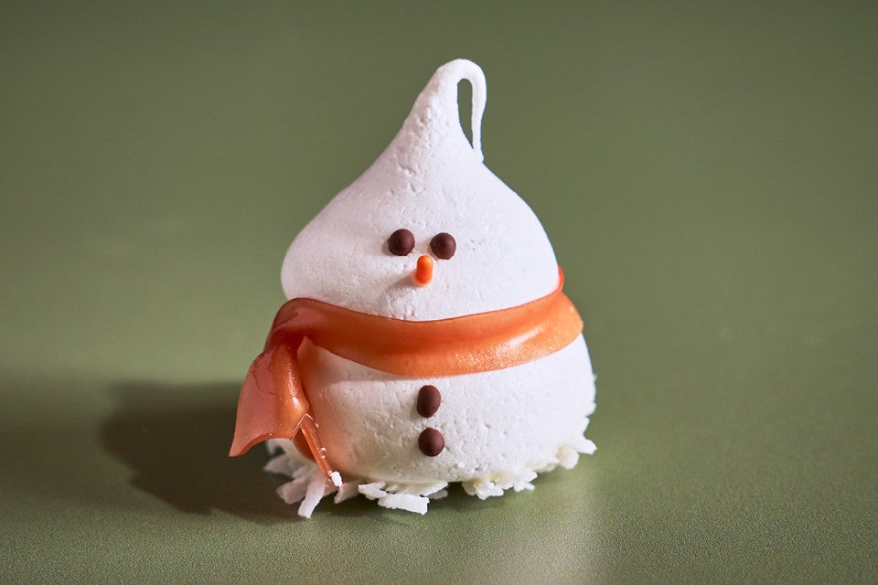 A single Snowman Meringue on a green backdrop
