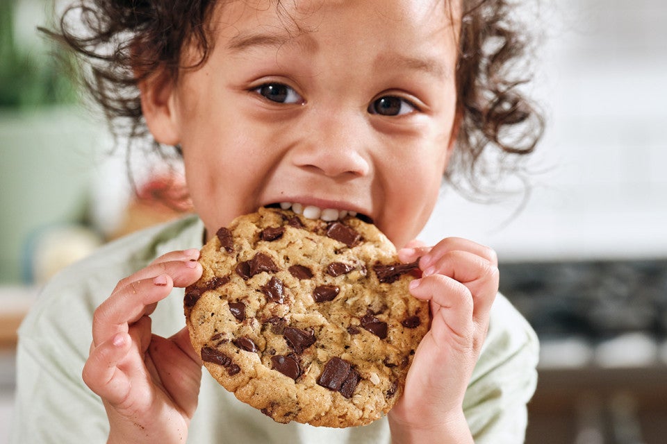 A child eating an oatmeal chocolate chip cookie