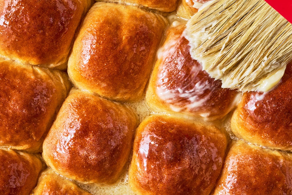 Brushing butter on top of Whole Wheat Dinner Rolls