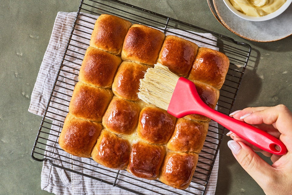 Brushing butter on Whole Wheat Dinner Rolls