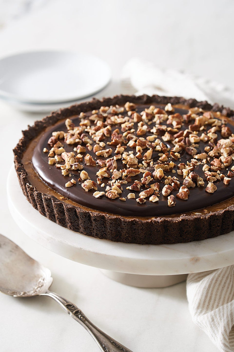 Salted Caramel Chocolate Tart on a cake pedestal