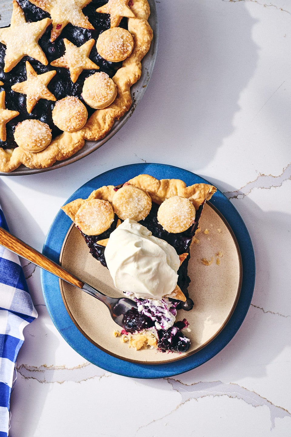 A slice of Fresh Blueberry Pie on a plate seen from above