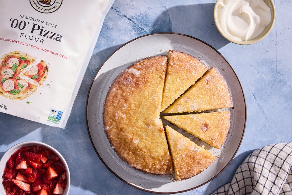 Lemon Ricotta Cake sliced on a plate with a bag of King Arthur Baking's '00 Pizza Flour