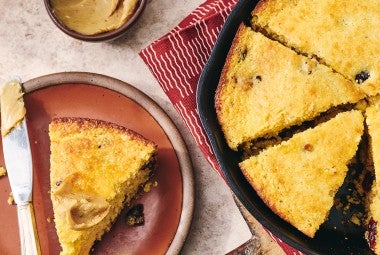 Cranberry Cornbread sliced and in a cast iron pan