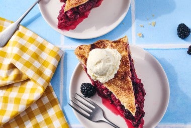 A slice of Gingery Blackberry Pie on a plate