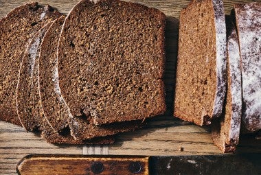 Classic Pumpernickel Bread sliced on a cutting board
