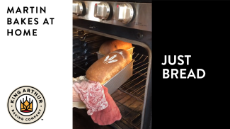 Pulling baked loaf of bread from the oven