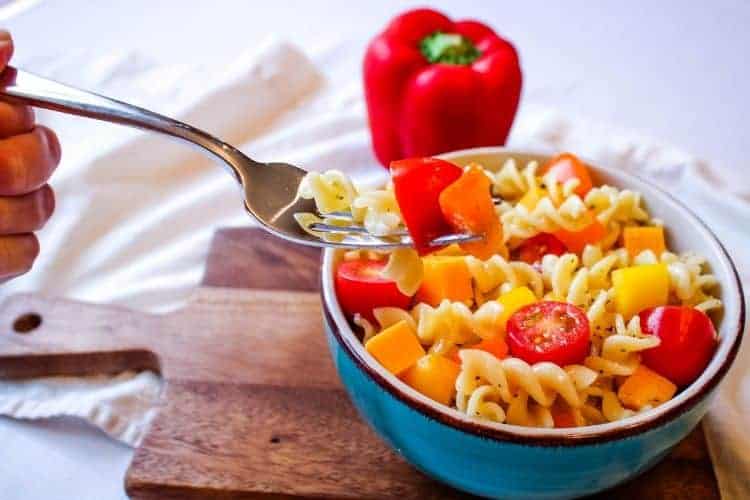 Fork in Italian Pasta Salad with with pepper in back
