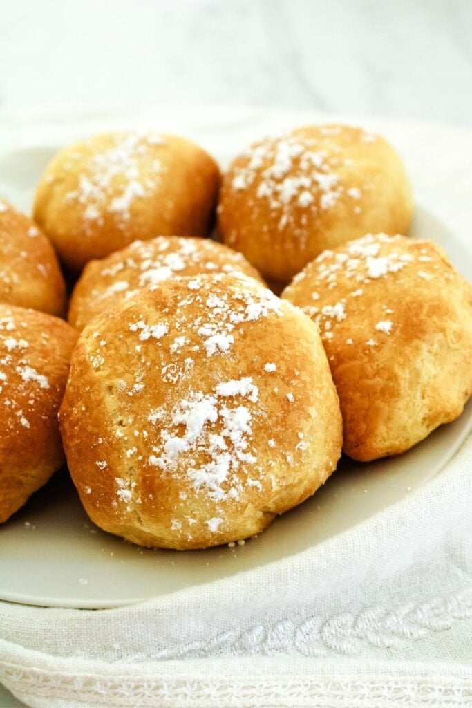 Air fried Oreos on a white plate with dusting sugar on top.