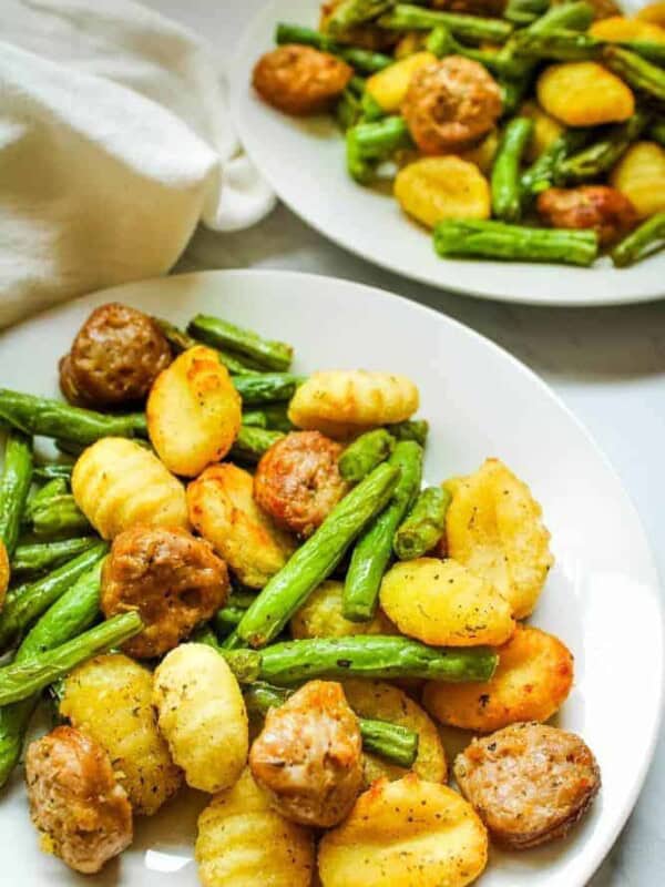 Sausage, Gnocchi, and Green Beans on a white plate