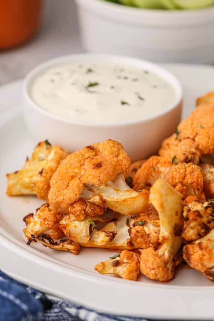 Air fryer buffalo cauliflower on a plate served with blue cheese