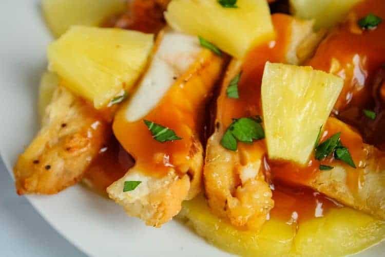 Closeup of Pineapple Chicken with pineapple chunks on a white plate