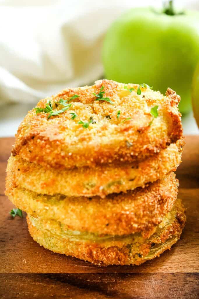 air fryer green tomatoes stacked on top of each other on a brown plate.