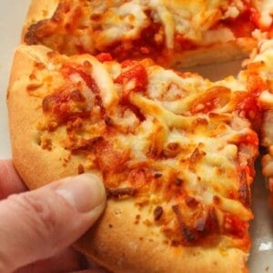 Air fryer pizza slice being held in hand
