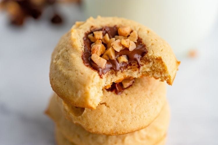 Bite taken out of the toffee chocolate thumbprint cookie