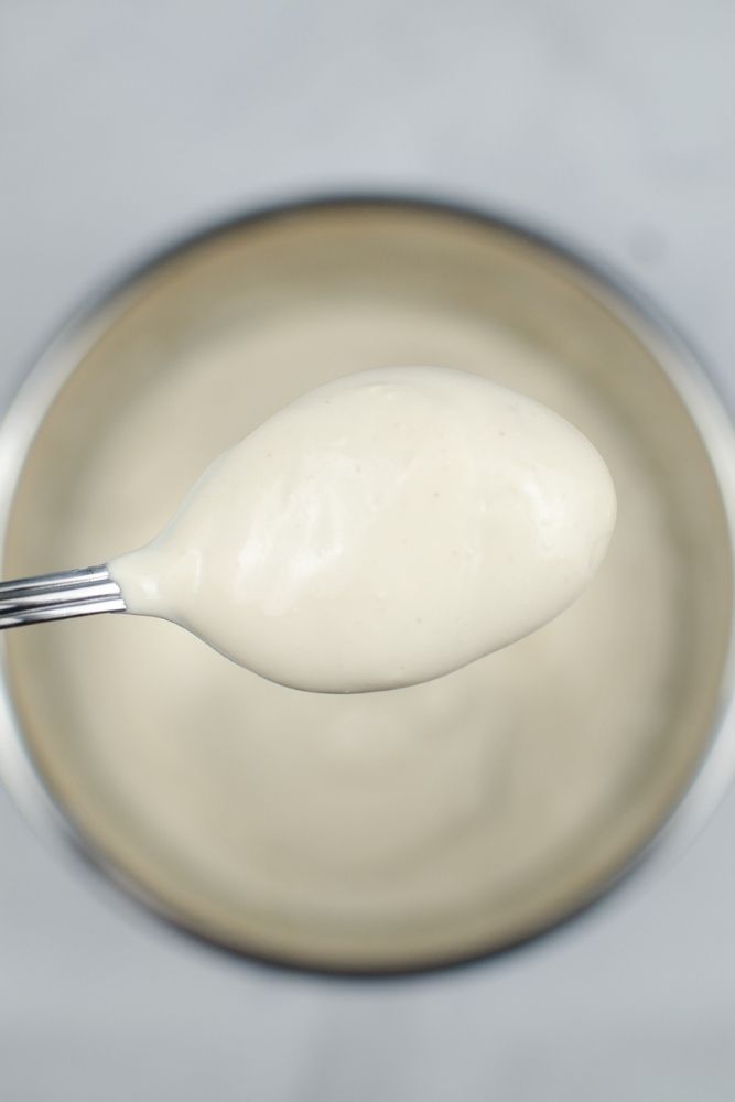 Spoonful of almond yogurt overhead of the Instant Pot inner pot