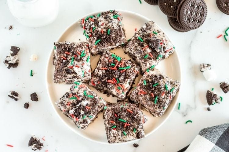 Finished Christmas marshmallow treats on a white plate in one layer