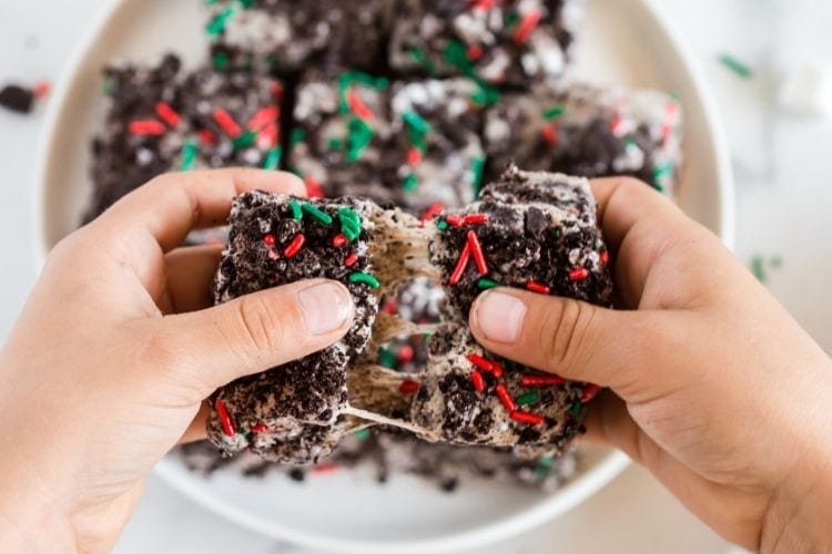 Marshmallow bars being pulled apart with marshmallow stretching across