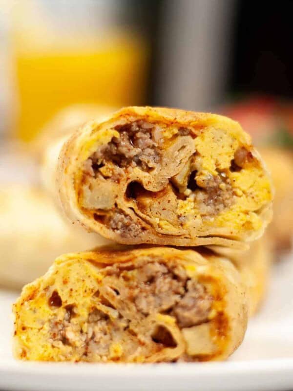 Closeup of air fryer breakfast burrito cut in half stacked on top of each other