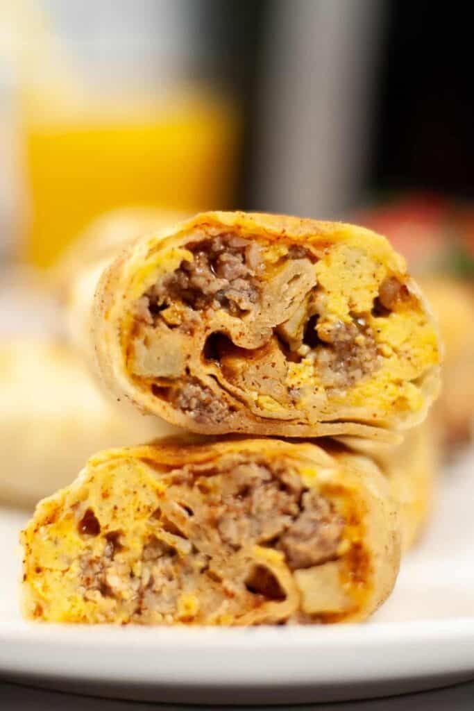Closeup of air fryer breakfast burrito cut in half stacked on top of each other
