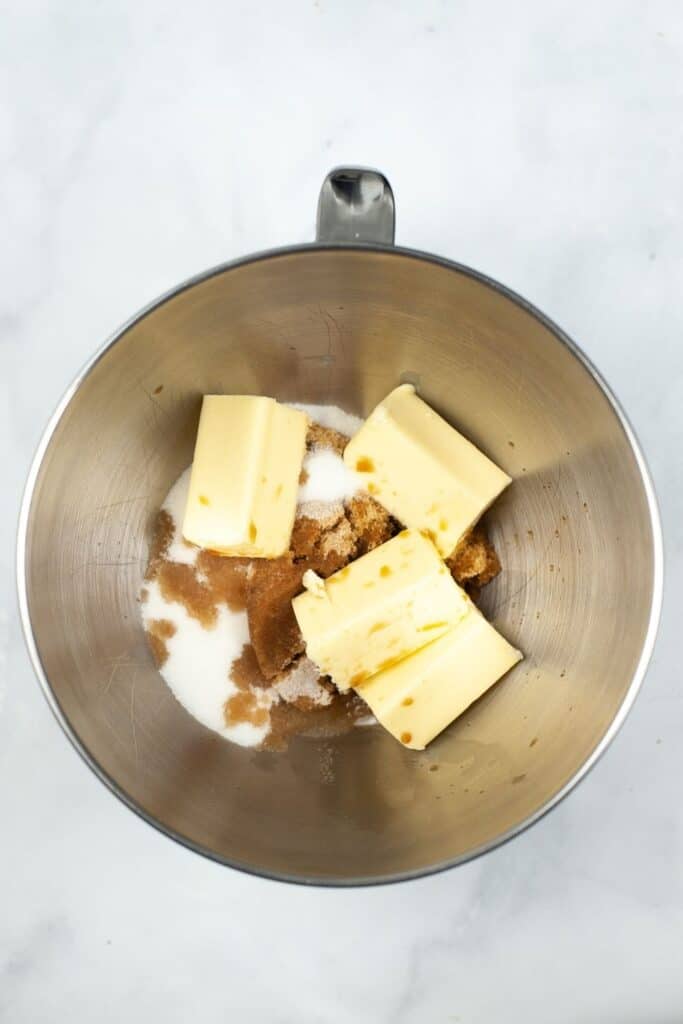 Sugars and butter inside a stainless steel mixing bowl unmixed