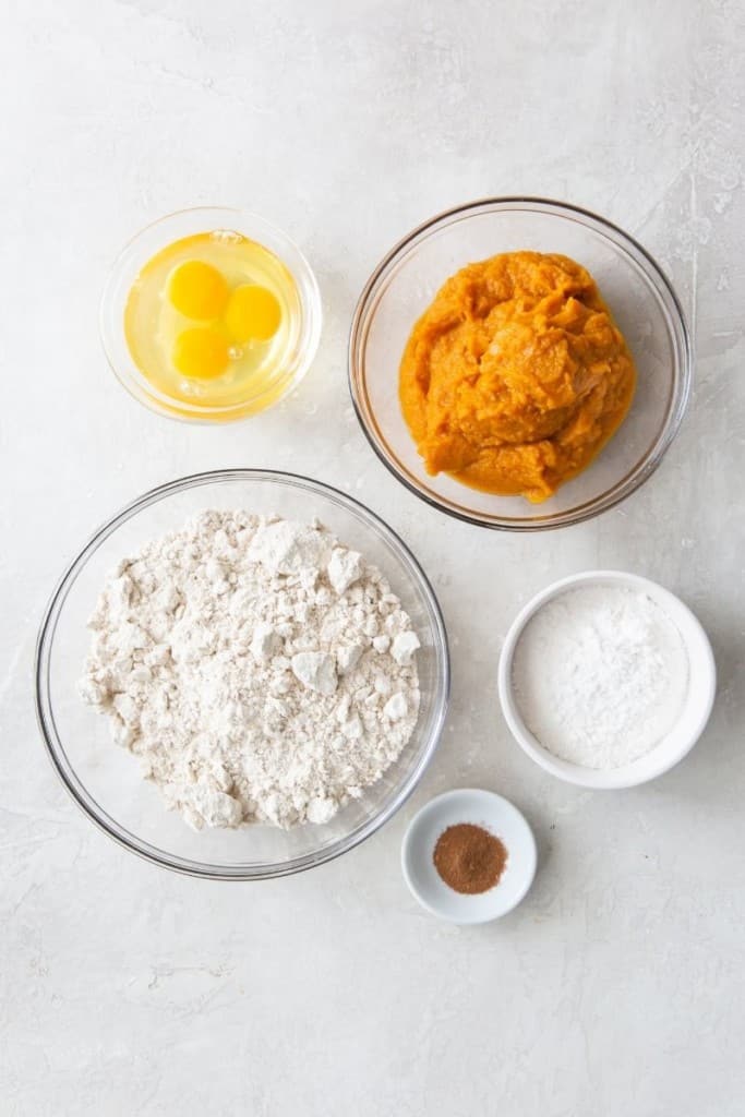 Bowls filled with ingredients needed to make pumpkin bread from cake mix and instant pudding